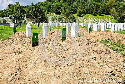 Potocari, Bosnia and Herzegovina - July 31, 2019. Green grave of last DNA identified victim of Srebrenica massacre between white t Editorial Stock Photo