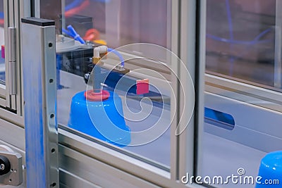 Pots on conveyor belt of plastic injection molding machine with robotic arm Stock Photo