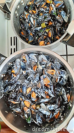 pots overflowing with freshly cooked mussels with creamy sauce Stock Photo