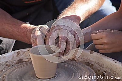 A potter craftsman transfers his skills to a student Stock Photo