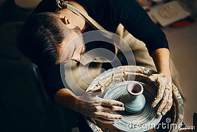 Potter modeling ceramic pot from clay on a potter`s wheel Stock Photo
