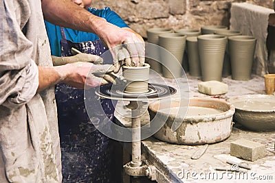 Potter teaches to sculpt in clay pot on turning pottery wheel Stock Photo