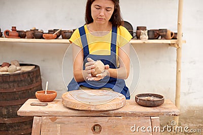 Potter with wet clay pot in hands. pottery hobby woman hands sculpt in clay in village Stock Photo
