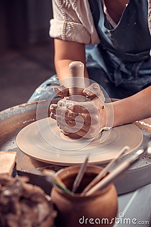 The potter works in the workshop. Hands and a potter& x27;s wheel close-up Stock Photo