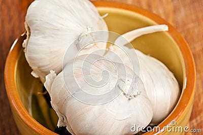 Pottery bowl of three garlic heads Stock Photo