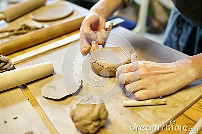 Pottery. A girl with a string in her hands cuts the clay Stock Photo