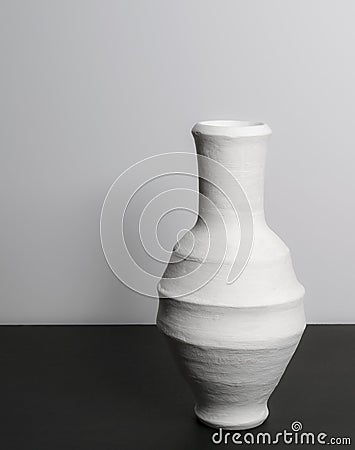 Pottery white vase on black table and white wall Stock Photo