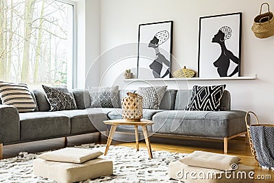 Poufs on carpet in bright african living room interior with grey Stock Photo