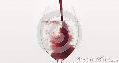 Pour blueberry juice into water in wine glass Stock Photo