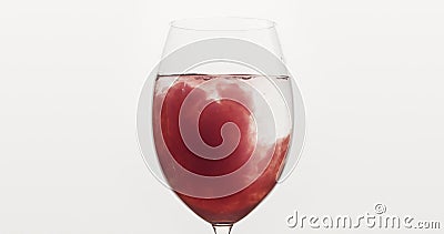 Pour blueberry juice into water in wine glass Stock Photo