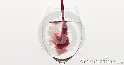 Pour blueberry juice into water in wine glass Stock Photo
