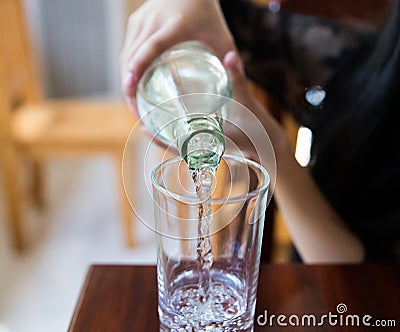 Pour a little water into a glass Stock Photo