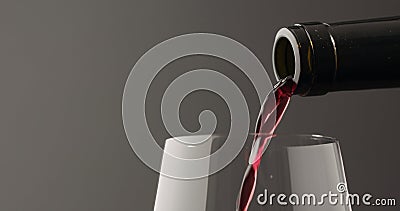 pour red wine into wineglass over black baground Stock Photo