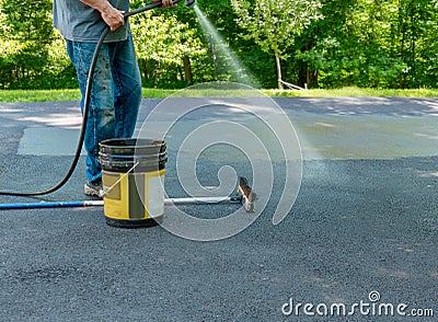 Pouring asphalt sealant on driveway Stock Photo