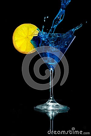 Pouring Blue Martini into the Martini Glass with Lemon Stock Photo