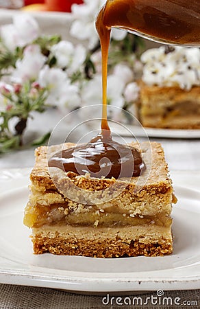 Pouring caramel sauce on piece of apple pie Stock Photo