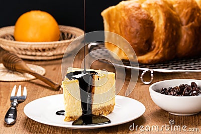 Pouring chocolate on delicious homemade mango cheesecake in white ceramic dish Stock Photo
