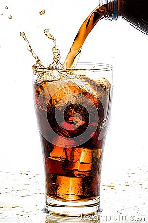 Pouring cola into glass with ice cubes Stock Photo