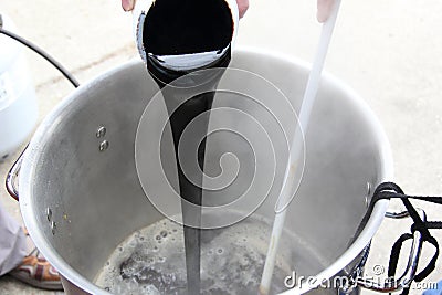 Pouring in dark LME into the Wort Stock Photo