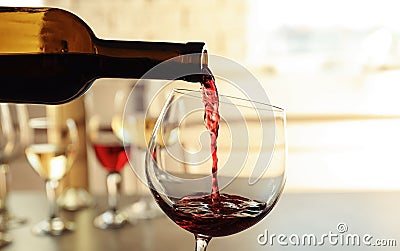 Pouring delicious red wine into glass Stock Photo
