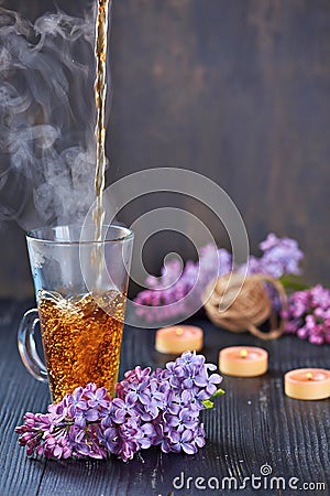 Pouring Healthy Tea with candles on a bakcground Stock Photo
