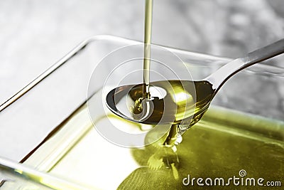 Pouring hemp oil into spoon over glass bowl Stock Photo