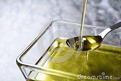 Pouring hemp oil into spoon over glass bowl Stock Photo