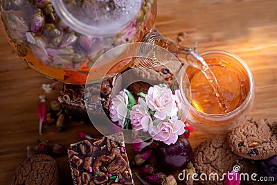 Pouring herbal tea from teapot into glass tea cup with brownie stack cake Stock Photo