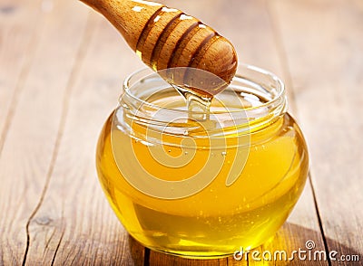 Pouring honey into jar Stock Photo