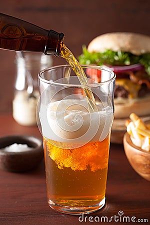 Pouring india pale ale beer into pint glass and fast food Stock Photo