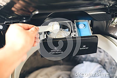 Pouring liquid laundry detergent In the washing machine Stock Photo