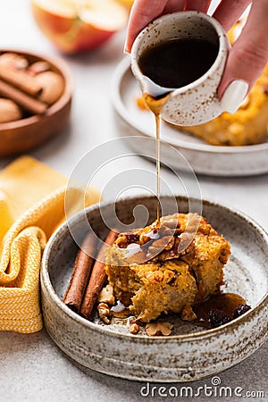 Pouring maple syrup onto pumpkin cake slice Stock Photo