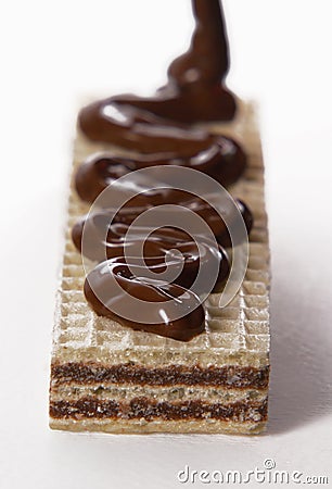 Pouring melted chocolate cream on chocolate cookie Stock Photo