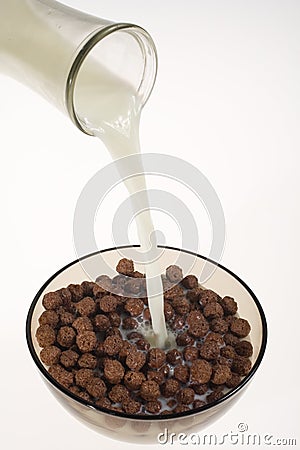 Pouring milk into chocolate cereal bowl Stock Photo