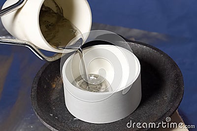 Pouring molten lead in ceramic ware. Stock Photo