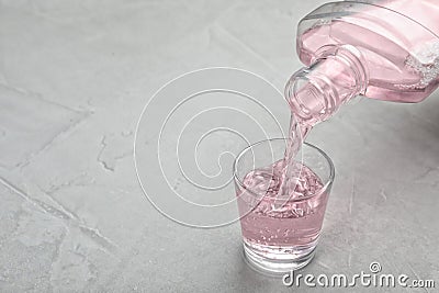 Pouring mouthwash in glass and space for text on light background Stock Photo