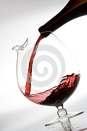 Pouring red wine into decanter Stock Photo