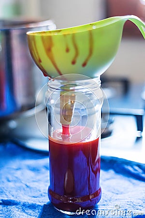 Pouring rose hip jam in the jars Stock Photo