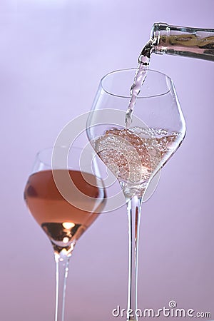 Pouring rose wine into wine glasses Stock Photo