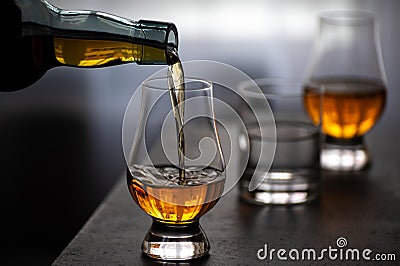 Pouring in tulip-shaped tasting glass Scotch single malt or blended whisky Stock Photo