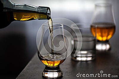 Pouring in tulip-shaped tasting glass Scotch single malt or blended whisky Stock Photo