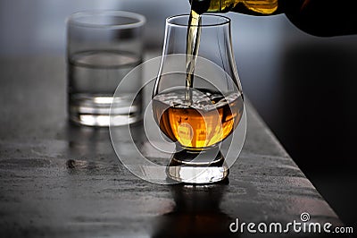 Pouring in tulip-shaped tasting glass Scotch single malt or blended whisky Stock Photo