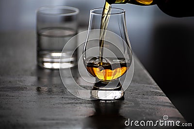 Pouring in tulip-shaped tasting glass Scotch single malt or blended whisky Stock Photo