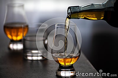 Pouring in tulip-shaped tasting glass Scotch single malt or blended whisky Stock Photo