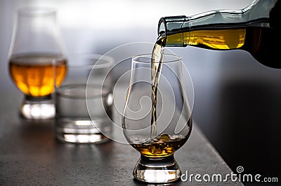 Pouring in tulip-shaped tasting glass Scotch single malt or blended whisky Stock Photo