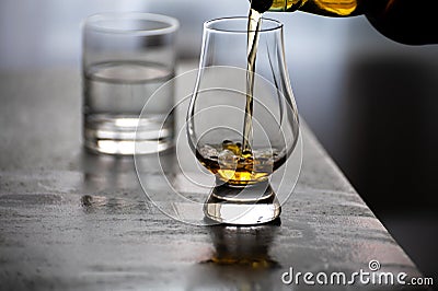 Pouring in tulip-shaped tasting glass Scotch single malt or blended whisky Stock Photo