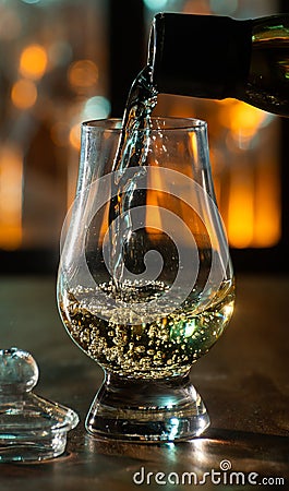 Pouring in tulip-shaped tasting glass Scotch single malt or blended whisky Stock Photo