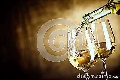 Pouring two glasses of white wine from a bottle Stock Photo