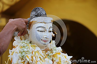 Pouring acrivity on white Buddhism statue Stock Photo