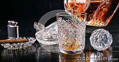 Pouring whiskey from a crystal decanter into a tumbler Stock Photo